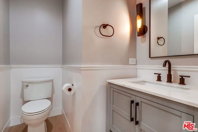 bathroom with vanity, hardwood / wood-style floors, and toilet