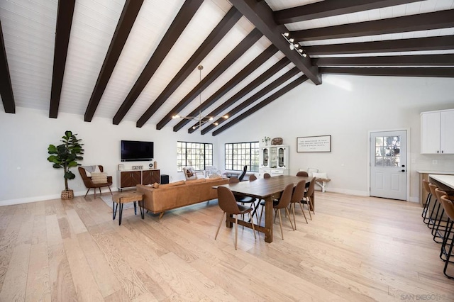 dining area featuring high vaulted ceiling, beam ceiling, and light hardwood / wood-style floors