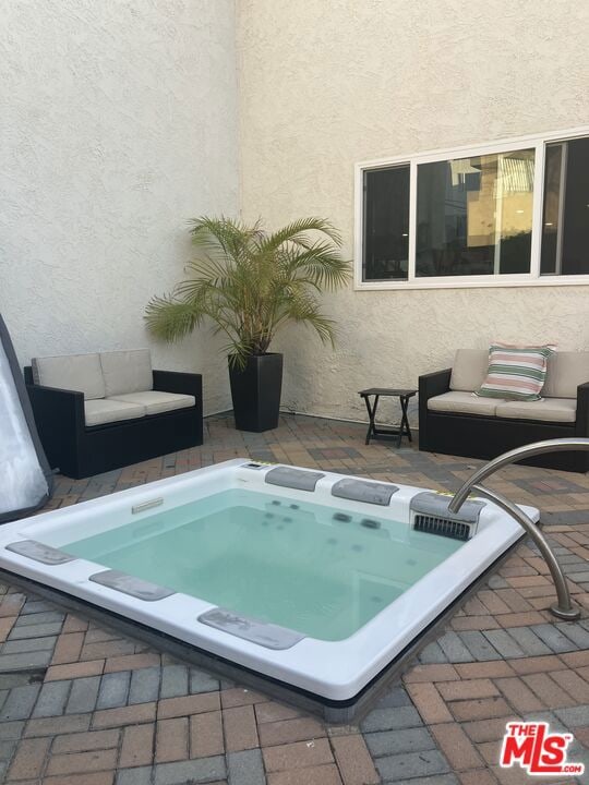 view of swimming pool with an outdoor hot tub