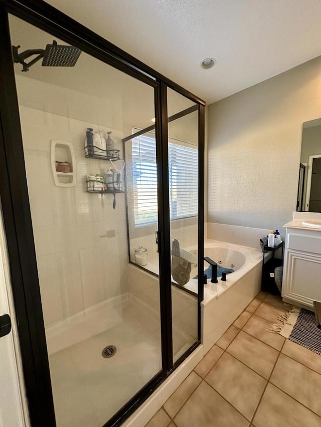 bathroom featuring tile patterned floors, vanity, and shower with separate bathtub