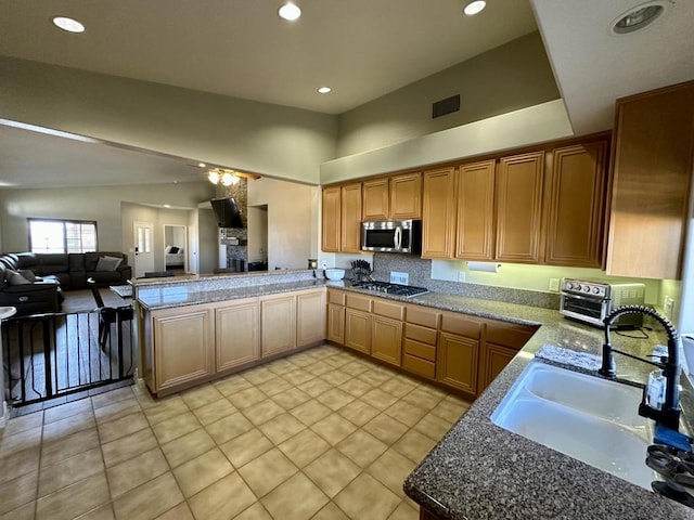 kitchen featuring sink, light tile patterned floors, appliances with stainless steel finishes, kitchen peninsula, and ceiling fan