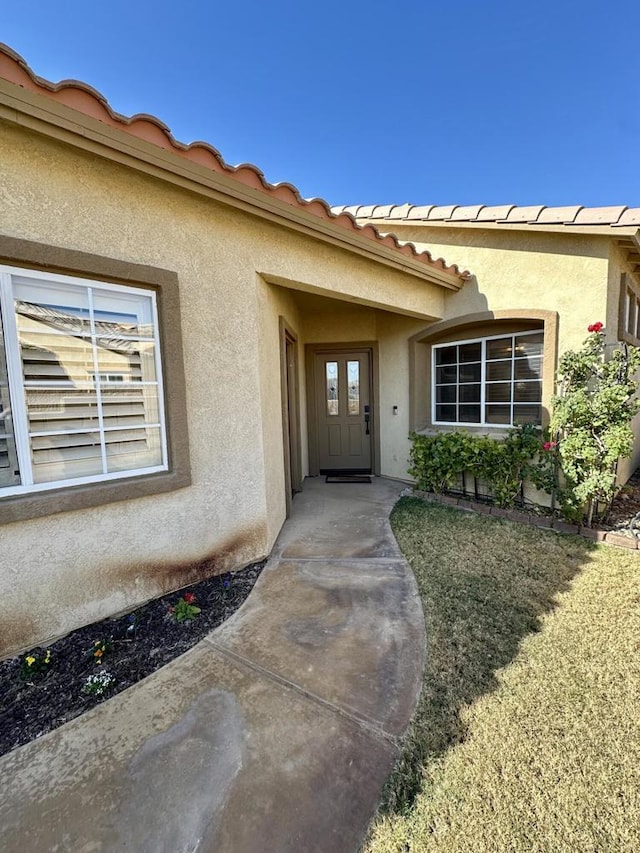 entrance to property featuring a yard