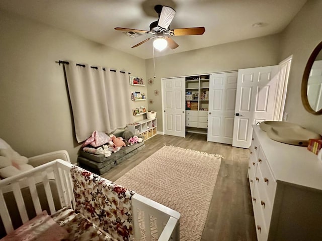 bedroom with ceiling fan, wood-type flooring, and a closet