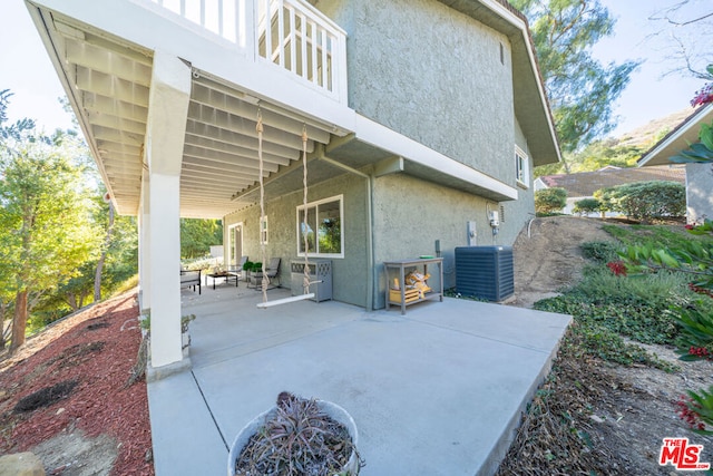 view of patio with cooling unit and an outdoor fire pit