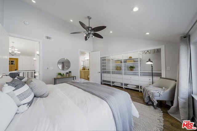 bedroom featuring high vaulted ceiling, dark wood-type flooring, ceiling fan with notable chandelier, and ensuite bath