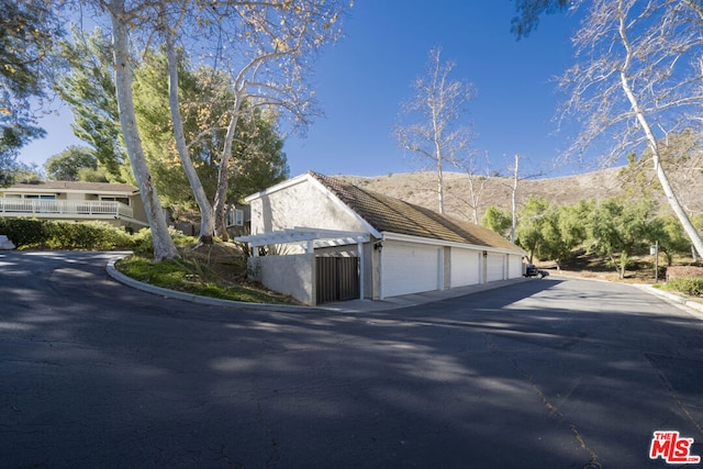 view of side of home with a mountain view and a garage