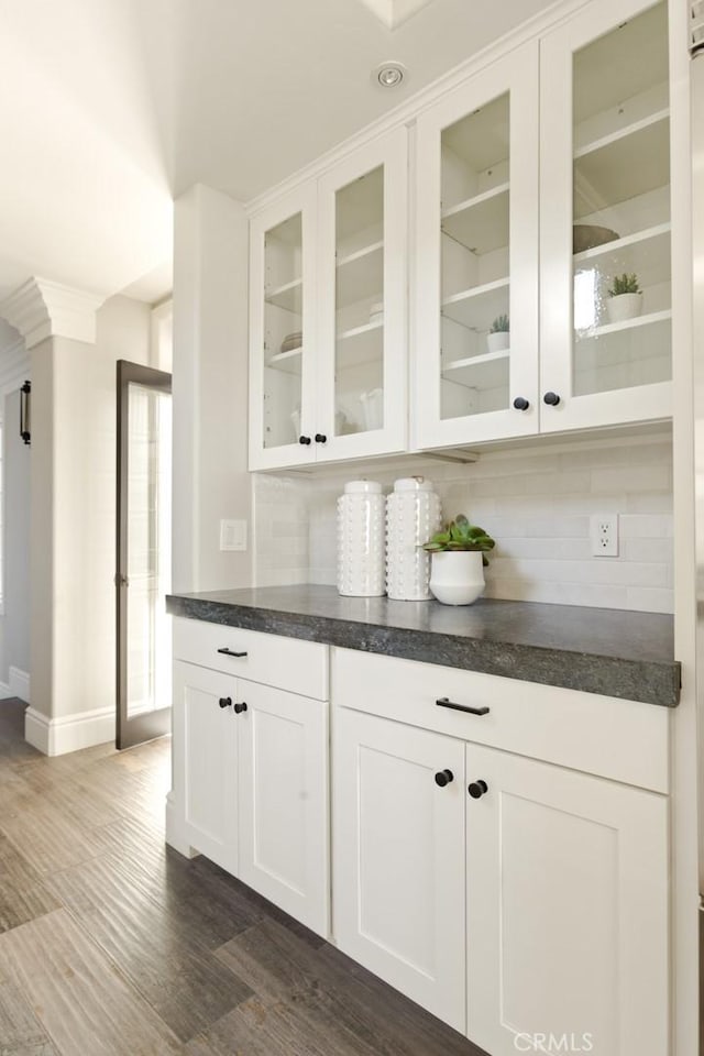 bar featuring tasteful backsplash, dark wood-type flooring, and white cabinets