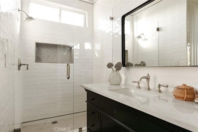 bathroom with tile walls, an enclosed shower, decorative backsplash, and vanity