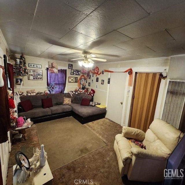 living room with ceiling fan, carpet flooring, and a drop ceiling