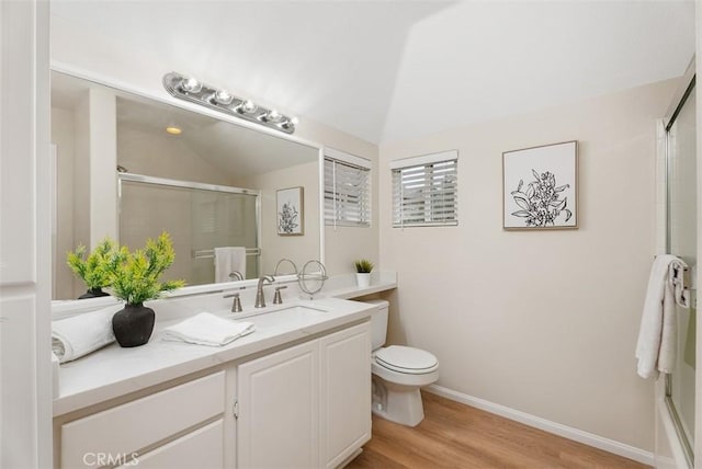 bathroom featuring vanity, hardwood / wood-style floors, a shower with door, and toilet