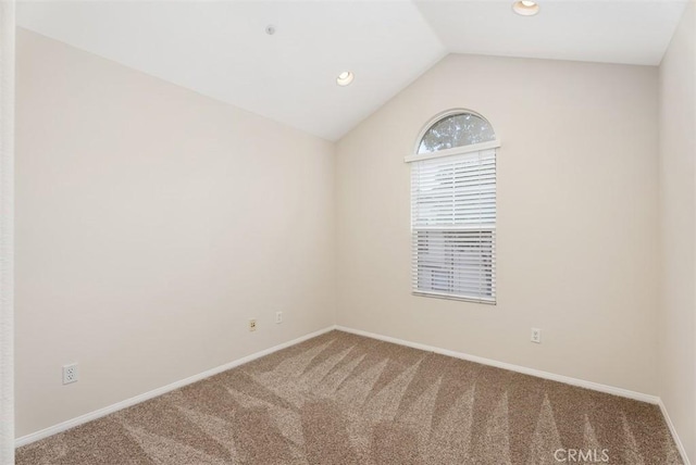 carpeted empty room with vaulted ceiling