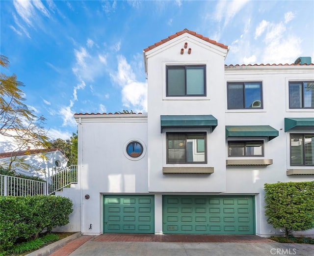 view of front of property with a garage, decorative driveway, and stucco siding