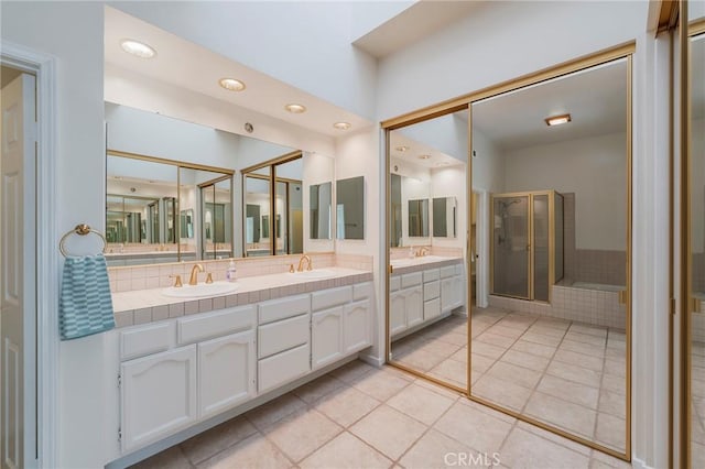 bathroom with double vanity, a stall shower, a sink, and backsplash