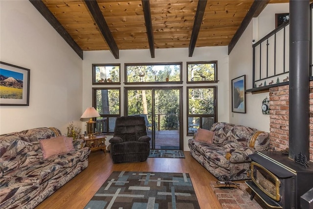 living room featuring hardwood / wood-style floors, wood ceiling, beamed ceiling, and a wood stove