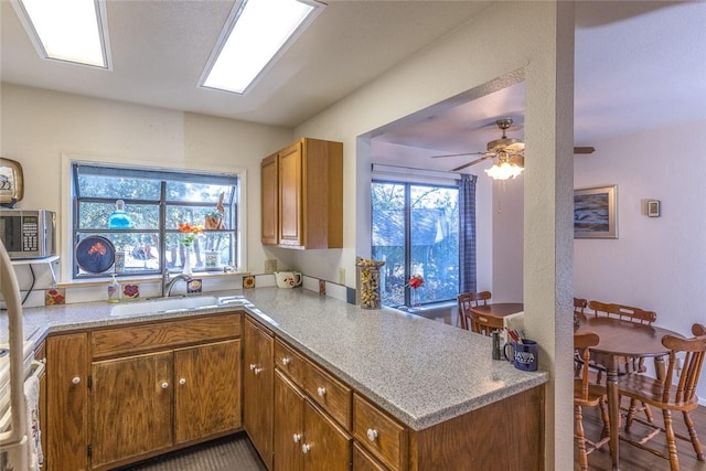 kitchen featuring sink, kitchen peninsula, and ceiling fan