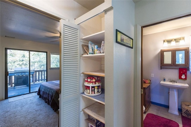 bedroom featuring light tile patterned flooring, sink, and access to outside