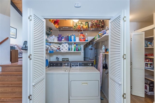 washroom featuring secured water heater, wood-type flooring, and washing machine and dryer