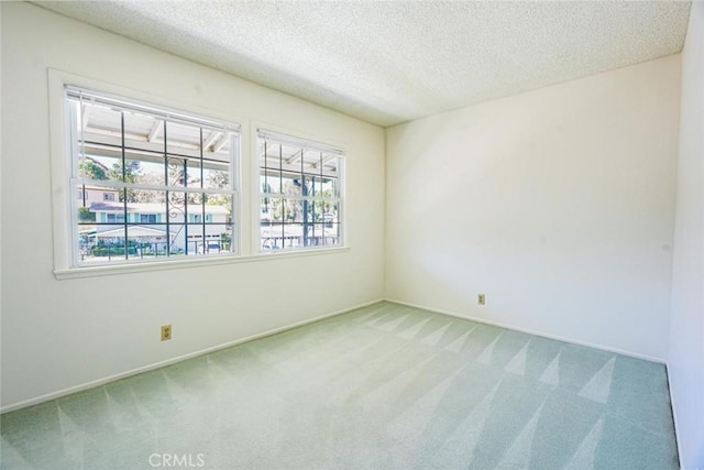 carpeted spare room with a textured ceiling