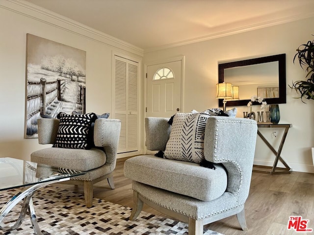 sitting room with ornamental molding and light wood-type flooring