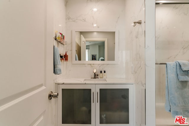 bathroom featuring walk in shower, vanity, and decorative backsplash