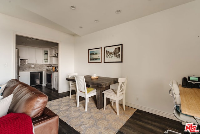 dining room featuring dark hardwood / wood-style flooring and vaulted ceiling