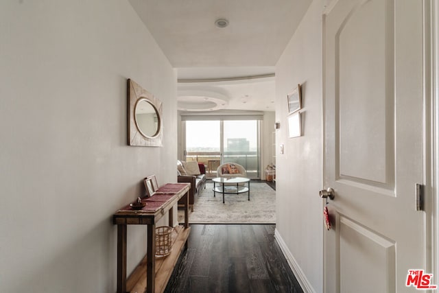 corridor with dark hardwood / wood-style flooring