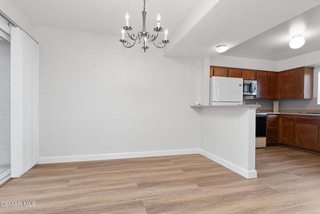 kitchen featuring sink, decorative light fixtures, white fridge, light hardwood / wood-style floors, and decorative backsplash