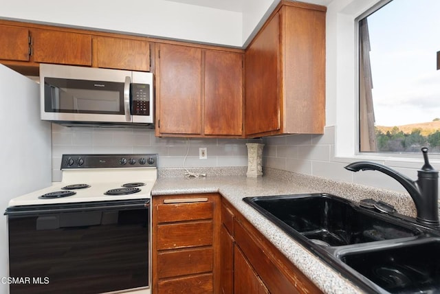 kitchen with sink, electric range, and backsplash