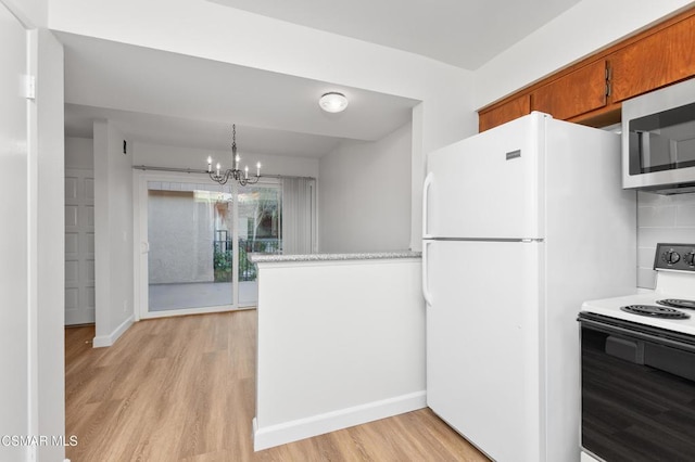 kitchen with electric stove, an inviting chandelier, white refrigerator, decorative light fixtures, and light wood-type flooring