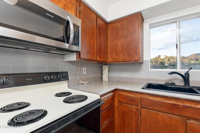 kitchen featuring black range with electric stovetop, sink, and backsplash