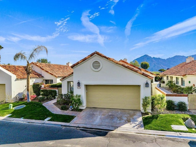 mediterranean / spanish house featuring a garage, a mountain view, and a front yard