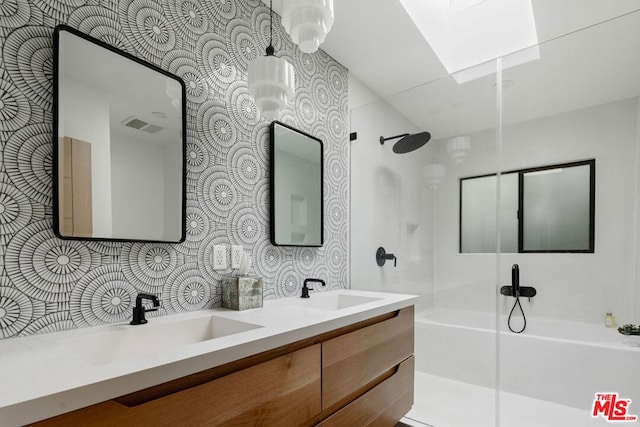 bathroom with plus walk in shower, vanity, and a skylight