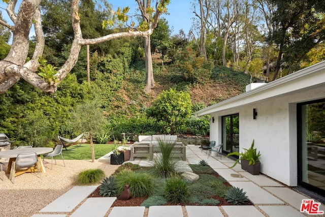 view of yard with an outdoor living space and a patio area