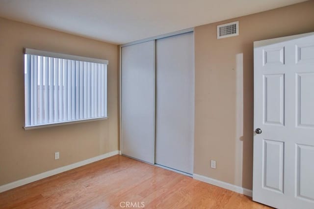 unfurnished bedroom with light hardwood / wood-style floors and a closet