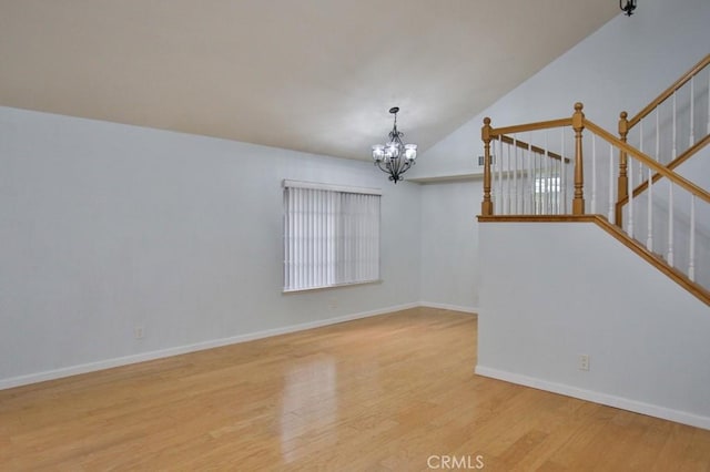 spare room with light hardwood / wood-style floors and a chandelier