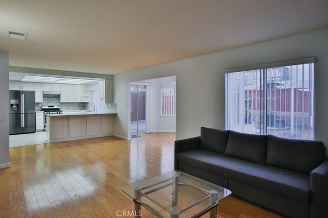 living room featuring sink and light wood-type flooring