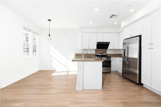 kitchen featuring stainless steel appliances, hanging light fixtures, white cabinets, and dark stone counters