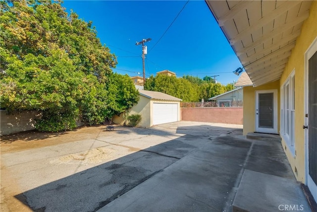 view of patio with an outbuilding and a garage