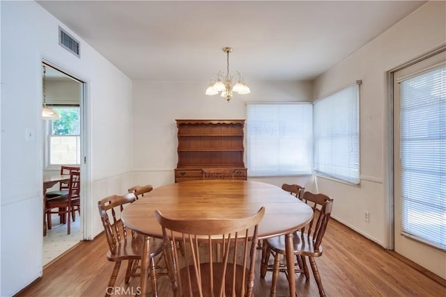 dining room with a notable chandelier and light hardwood / wood-style flooring