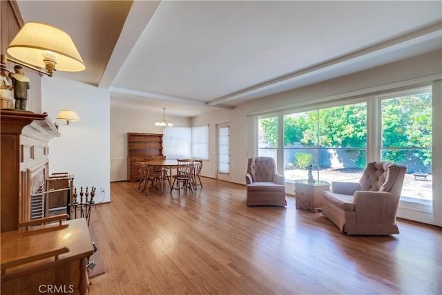 living room with light hardwood / wood-style floors and a notable chandelier