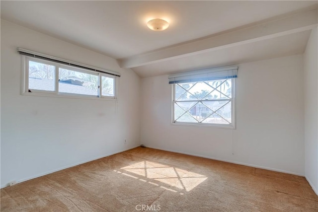 carpeted empty room featuring vaulted ceiling with beams