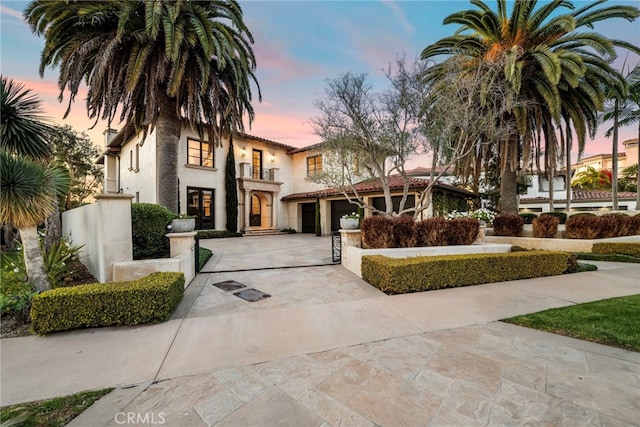 mediterranean / spanish-style home featuring a garage and a balcony