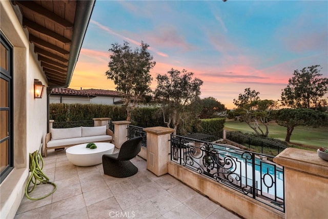 patio terrace at dusk with a balcony and outdoor lounge area