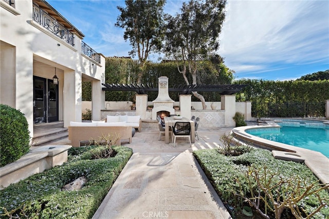 view of pool featuring a patio area and an outdoor living space with a fireplace