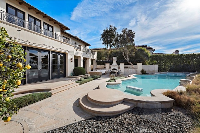 view of swimming pool featuring a patio, an in ground hot tub, and french doors