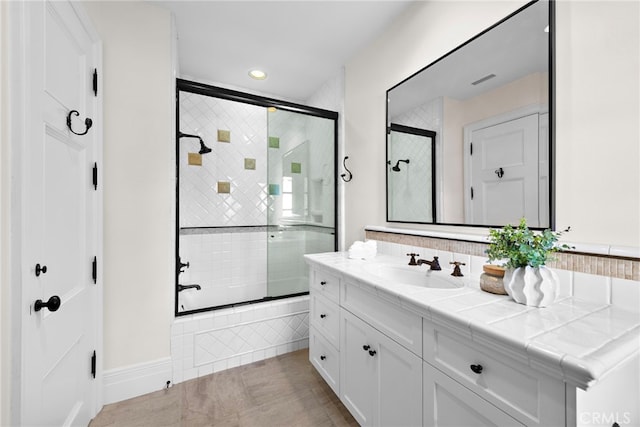 bathroom featuring vanity and shower / bath combination with glass door