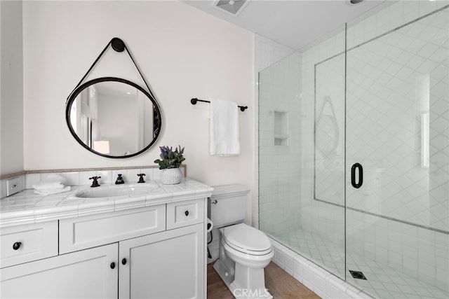 bathroom with walk in shower, vanity, and toilet