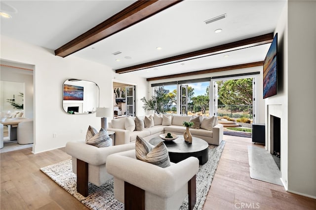 living room with beam ceiling and light hardwood / wood-style floors