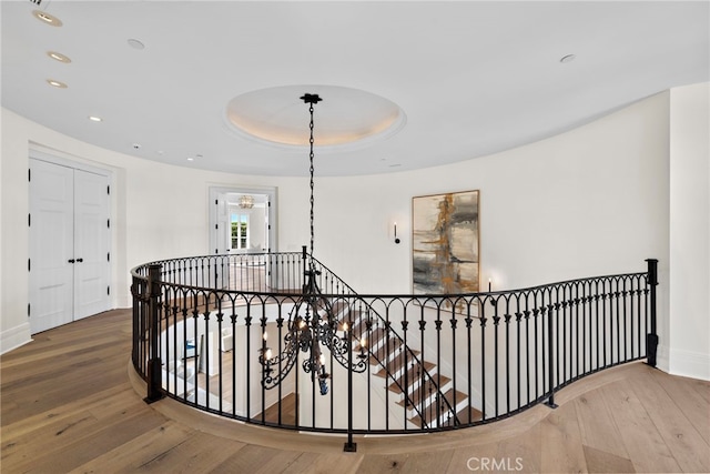 hallway with hardwood / wood-style flooring and a tray ceiling