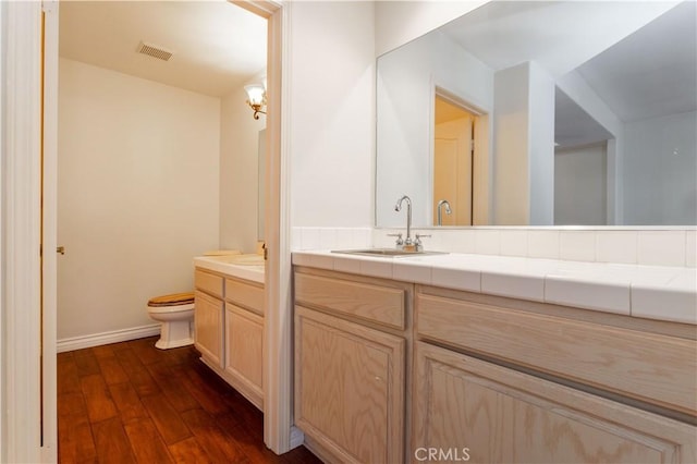 bathroom with vanity, hardwood / wood-style floors, and toilet